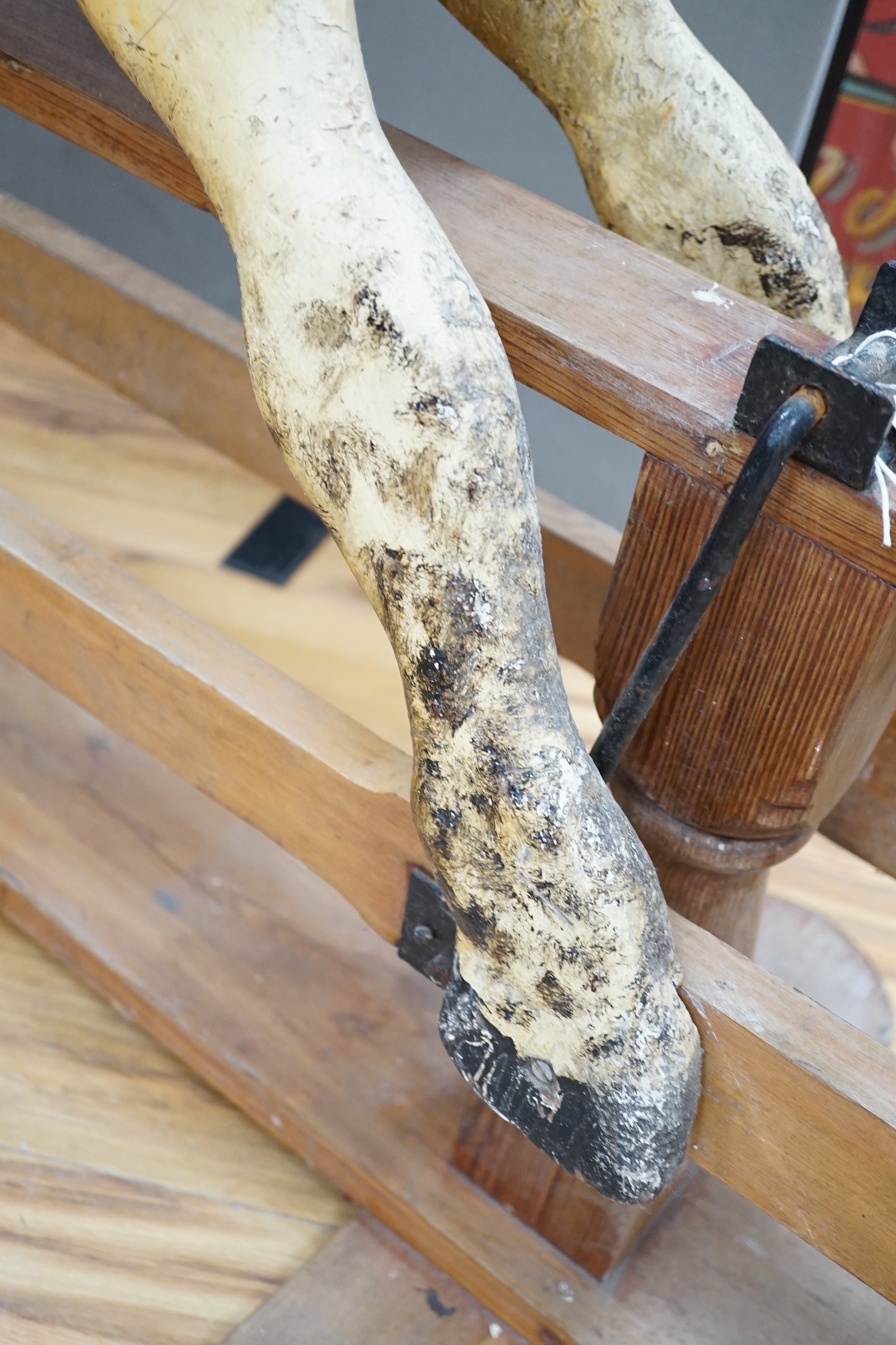 A Rocking horse on a wooden pedestal rocker, with plaster, composite body, height, 97cm, length 152cm